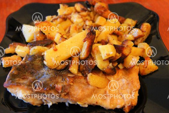 Fried potato and fried fish and the black plate