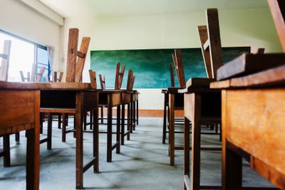 chair and table in class room with black board...