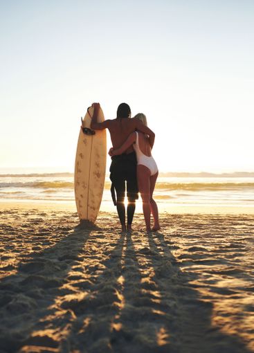 Seaside, couple and hug with surfboard for love in...