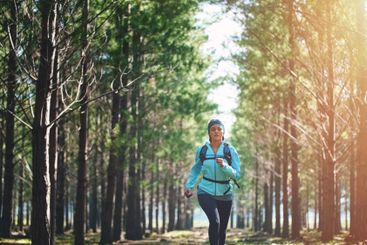 Woman, woods and trail running for exercise, nature and...
