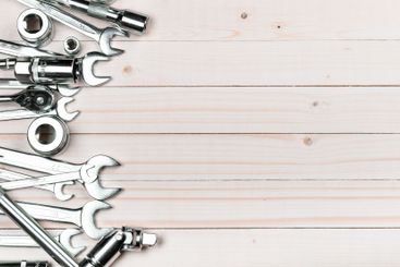Assorted hand tools arranged on a wooden surface ready...