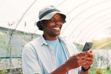 Farming, black man and smile with phone for agriculture,...