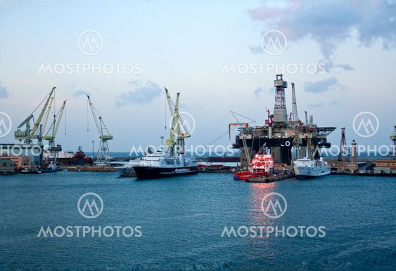 Cranes and boats in Naples sea port on sunrise
