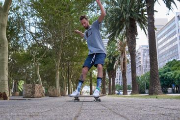 Skateboard, fitness and urban with man in city for...