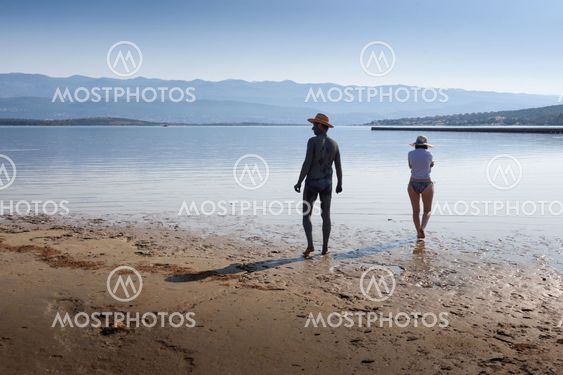 Par insmetande i lera på stranden i Kroatien
