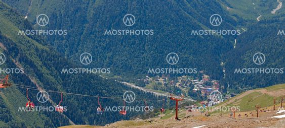 People on the chairs of cableway. Dombai mountains