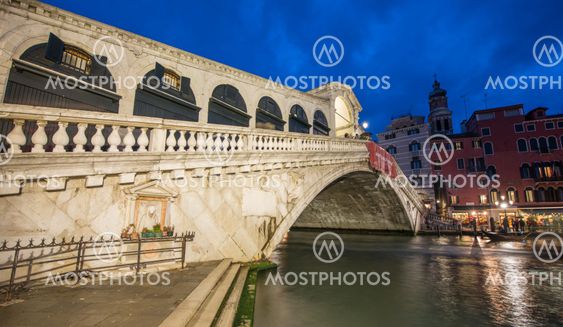 VENICE, ITALY - MAR 23, 2014: Rialto Bridge at sunset with tourists. The city has 21 million visitors each year