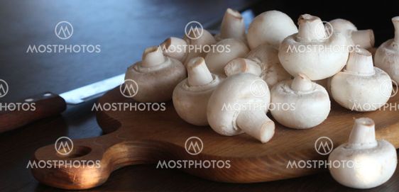Food background of fresh champignons at the old cutting...