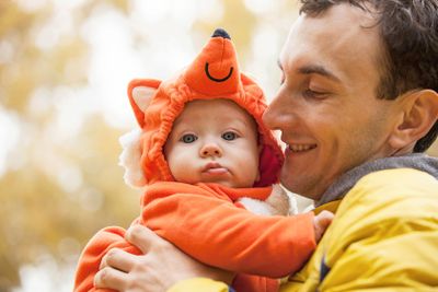Young man and his little son in fox costume