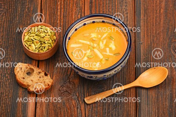 Bowl of pumpkin soup on wooden table