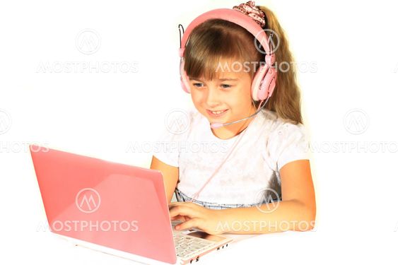 Beautiful little girl with headphones and a computer. Computer and headphones pink.