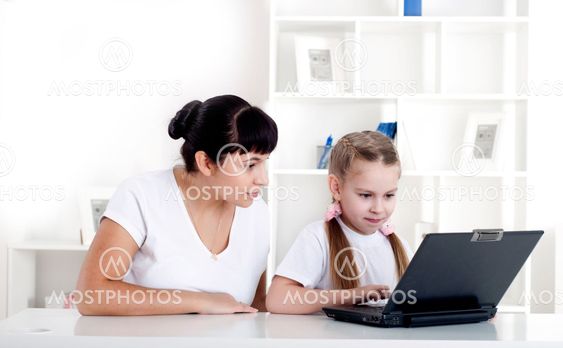 Mom and daughter are working together for a laptop