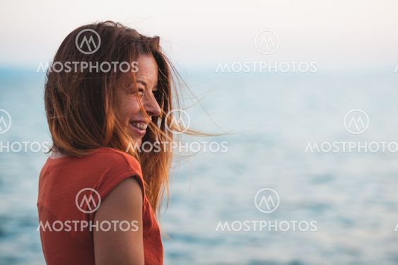 Young woman enjoying sunset by the sea