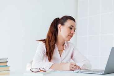 Brunette businesswoman sitting at desk in office with...