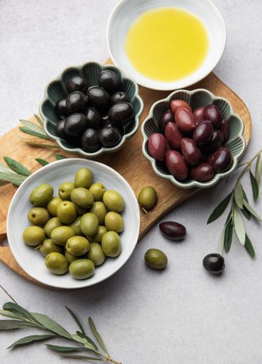 Variety of olives, olive oil, and olive branches served...