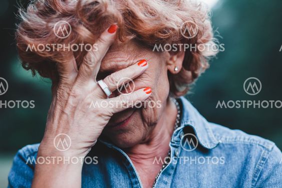 Older women worrying with her hands over her face