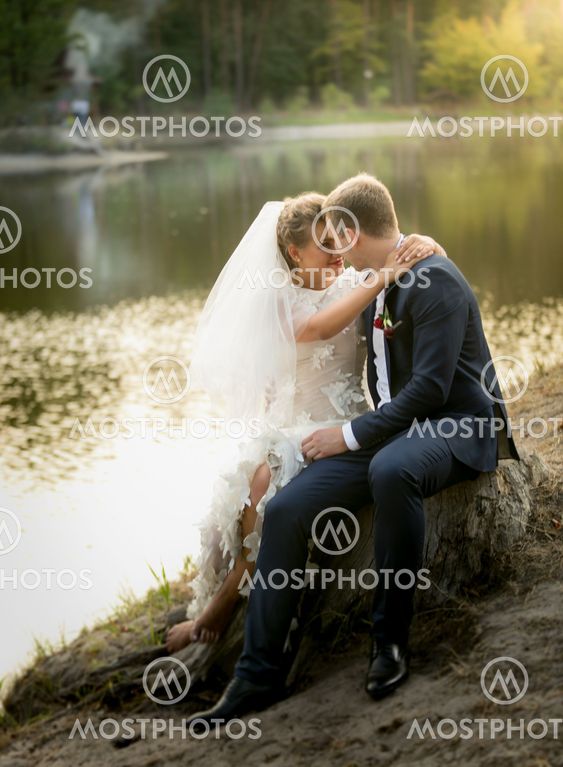 just married couple hugging on the riverbank