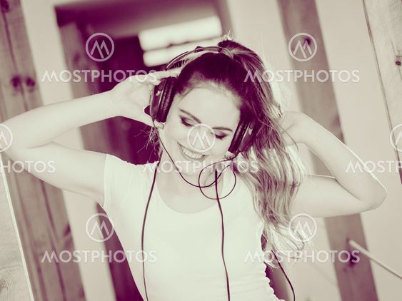 Woman with headphones listen music and dance.