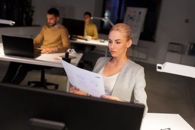 designer working with papers at night office
