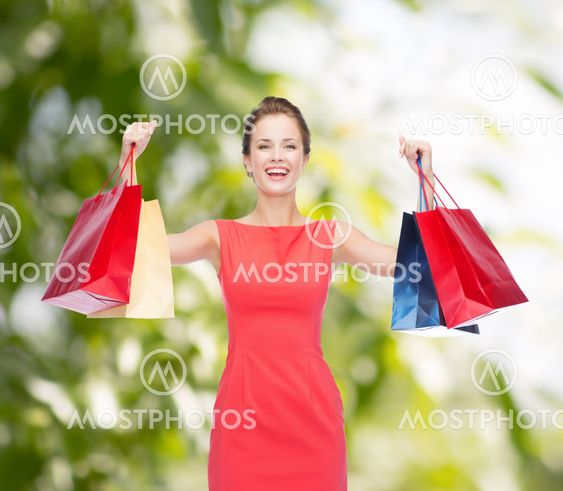 laughing elegant woman in dress with shopping bags