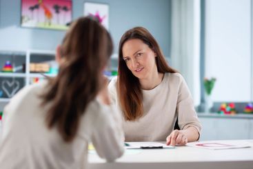 Professional psychiatrist comforting sad ADHD child