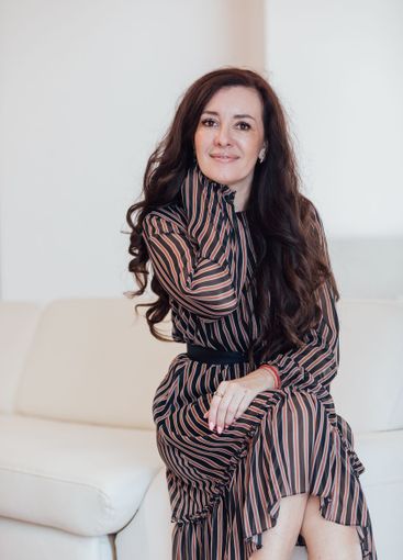 Beautiful fashionable brunette woman sitting on a white...