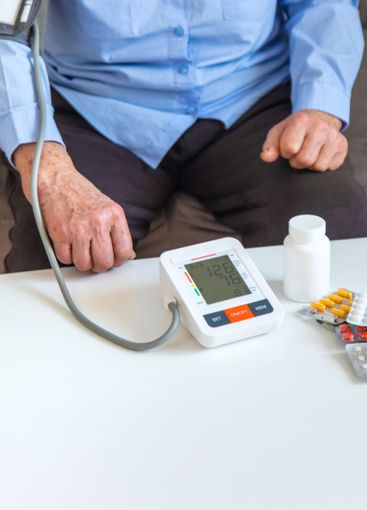 An old woman measures her blood pressure. Selective focus.