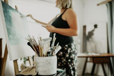 Art, bushes and painting, woman in studio at home with...