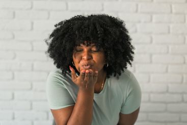 Catch my kiss. Lovely romantic African American woman...