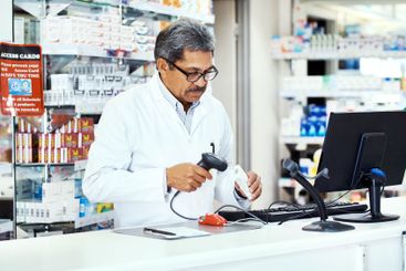 Pharmacist, computer and scan for stock, medicine and...