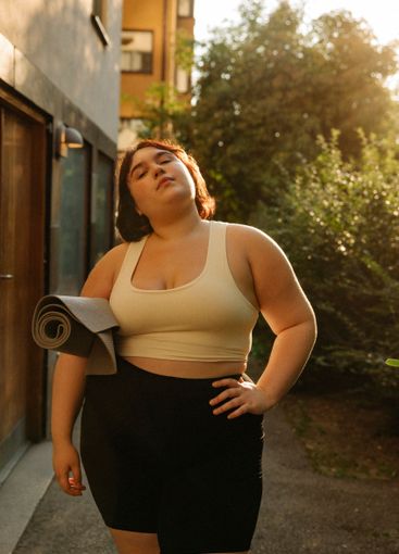 Portrait of confident young woman with hand on hip...