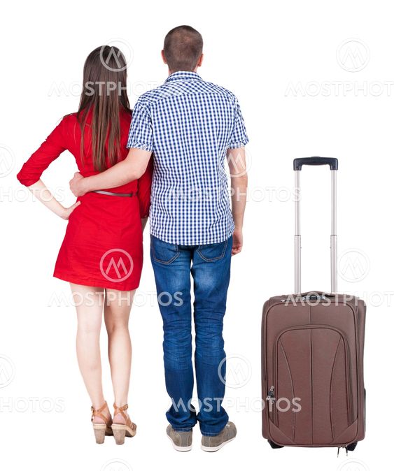 Back view of young couple traveling with suitcas .