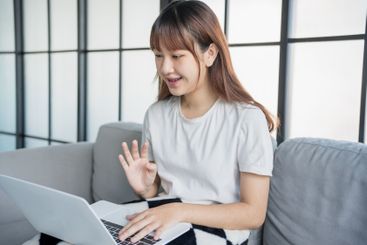 Asian woman video call with family by using laptop