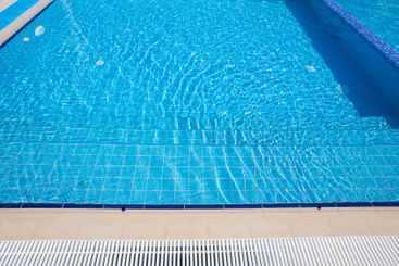Clear blue swimming pool under bright sunlight inviting...