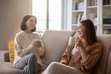 Happy european young women in casual with cups drink...