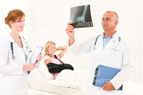Medical doctors look x-ray patient broken arm