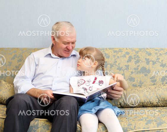 grandfather and granddaughter reading book