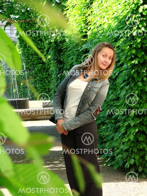 A young woman is walking in a park