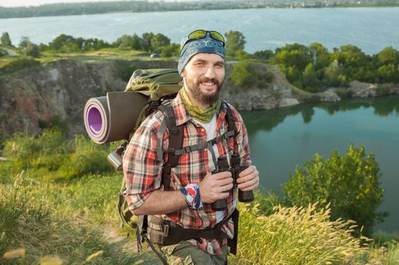 Young caucasian man with backpack walking on the top of...