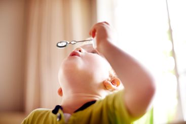 Home, blowing bubbles and boy with fun, game and playful...