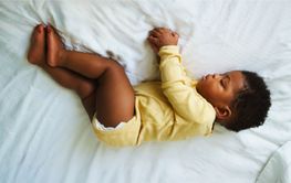 Baby Sleeping Peacefully on White Bed Sheets in Cozy...