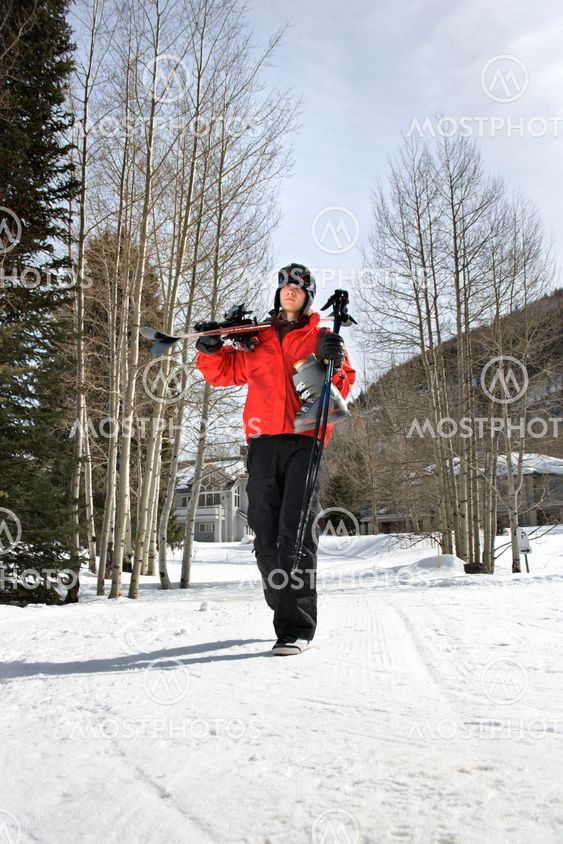 Teenager carrying ski gear.