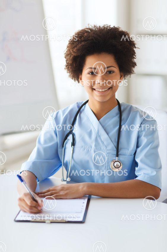 happy female doctor or nurse writing to clipboard