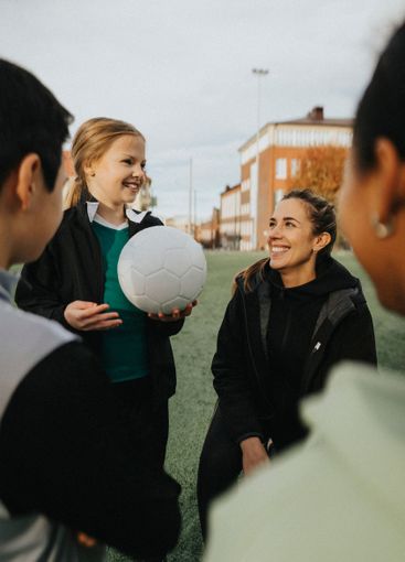 Smiling instructor giving advice to male and female...