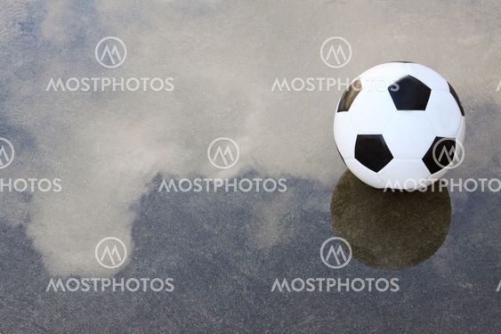 soccer football on wet ground with water reflection cloud...