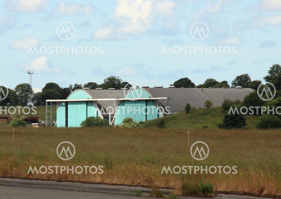 Airplane hangar isolated at airfield with clouds