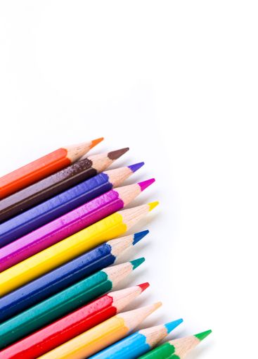 Vibrant colored pencils arranged neatly on a white...