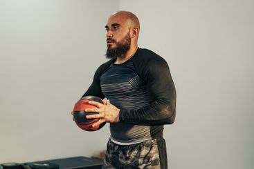Athlete prepares for training session with medicine ball...
