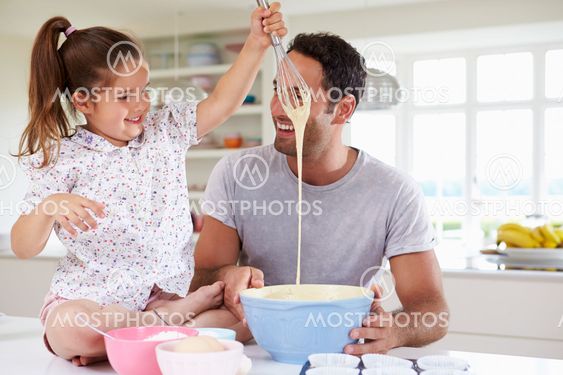 Father And Daughter Baking Cake In Kitchen