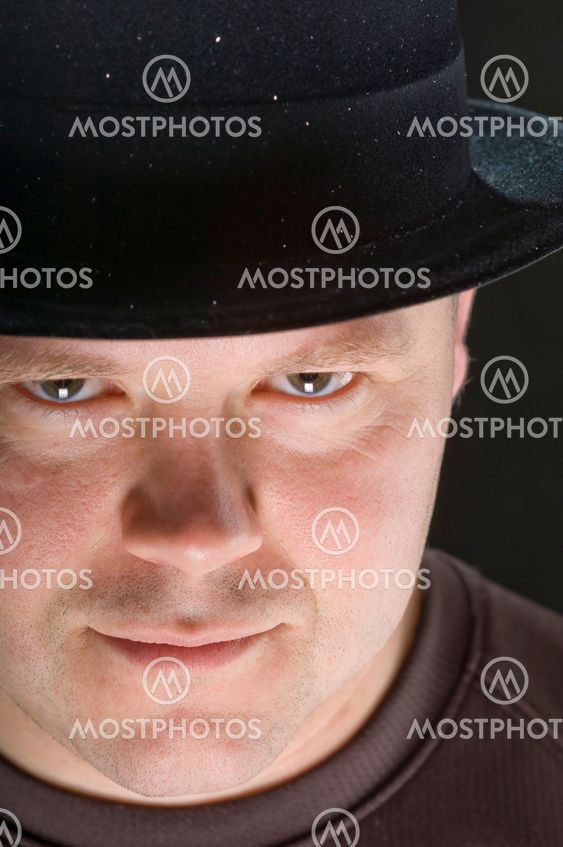 Man i hatt som stirrar uppmärksamt